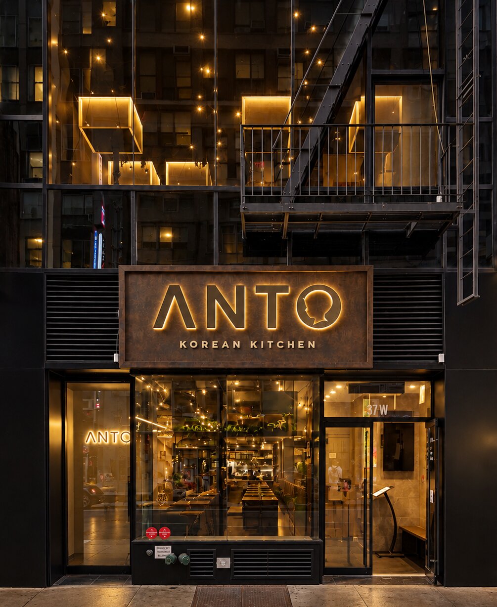 The Anto facade on 32nd Street at night, the sign glowing over the storefront
