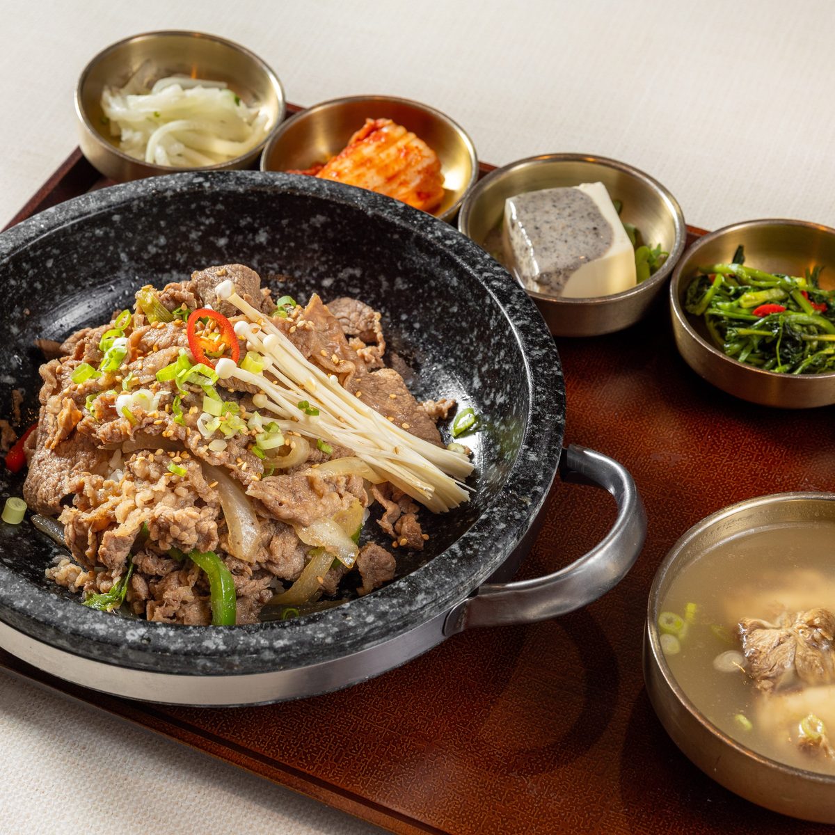 Ttukbaegi bulgogi bubbling in a stone pot with glass noodles