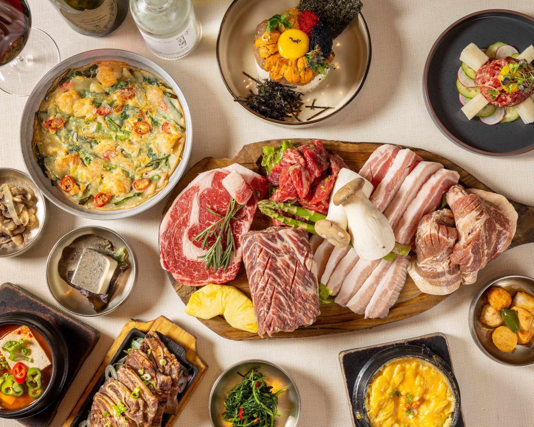 The table set for everyone, the meat board at the center and banchan all around